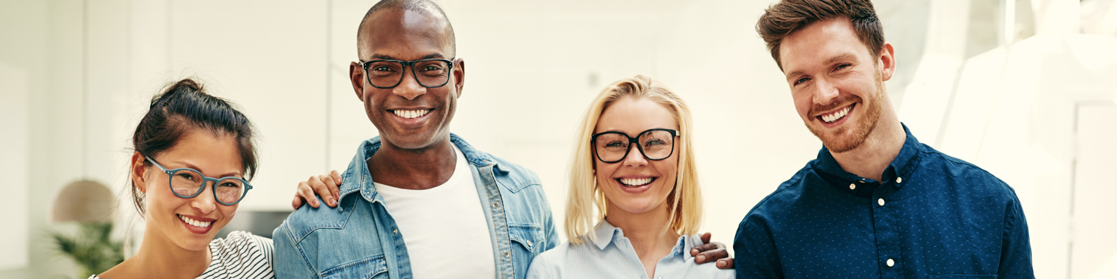 Smiling group of young businesspeople standing in an office.