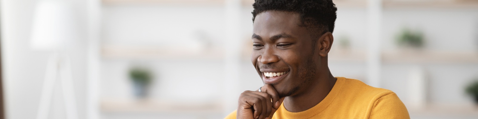 photo of a man working from home on a laptop, smiling.