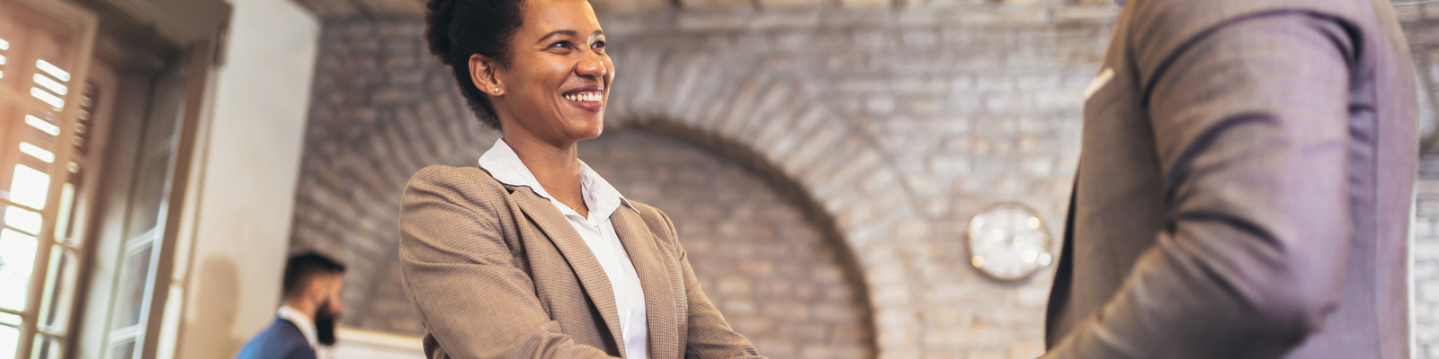 Young modern business people in smart casual wear shaking hands while working in the creative office
