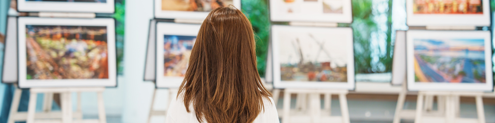 Young female tourist looking at an Art Gallery exhibition at a museum.