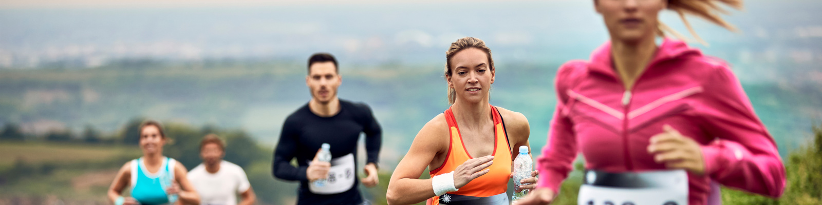 Group of athletic people running marathon in nature.