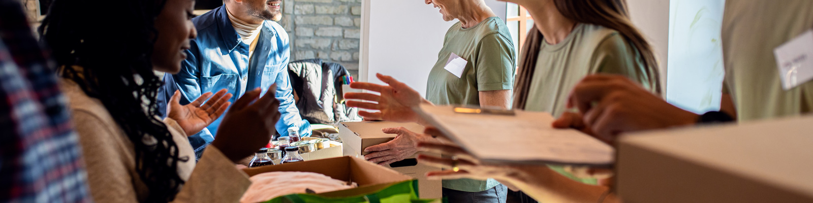 Group of volunteers with working in community charity donation centre.