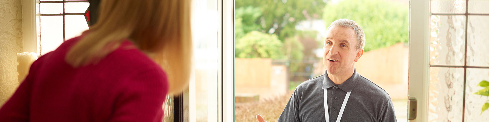Photo Of Person Opening Their Front Door and Talking to a Face to Face Fundraiser Who is Holding a Clipboard.
